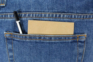 Blue jeans back pocket with paper and pen. 